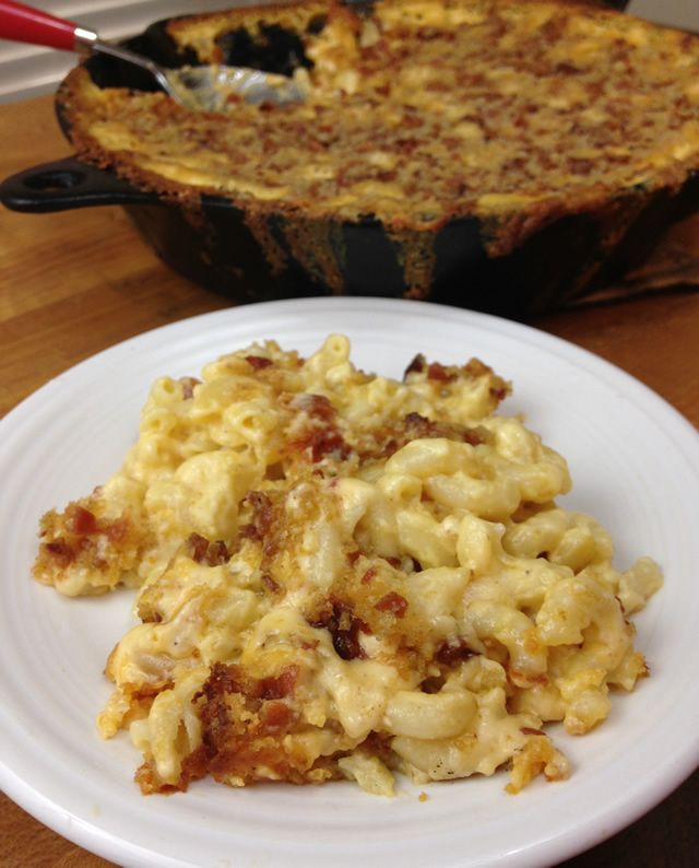 a white plate topped with macaroni and cheese next to a casserole dish