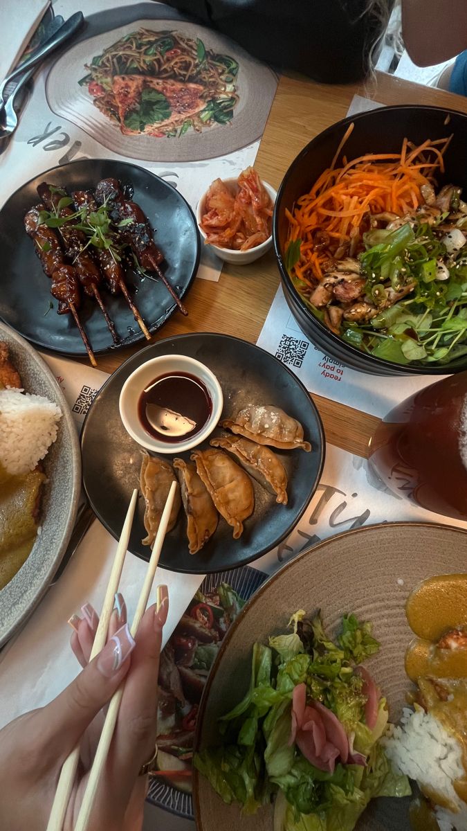 several plates of food on a table with chopsticks