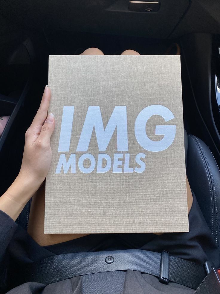 a person holding up a piece of paper with the word img models printed on it