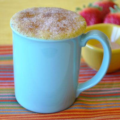 there is a powdered sugar on the top of a mug next to strawberries