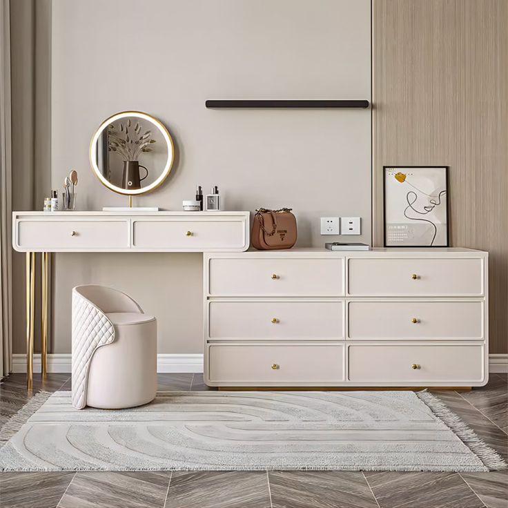 a white dresser sitting next to a mirror on top of a wooden floor in a room