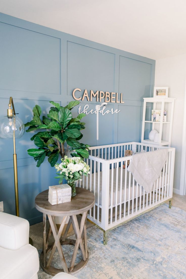 a baby's room with a white crib and blue walls