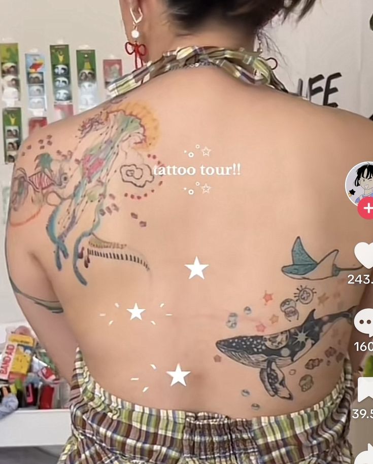 the back of a woman's body with tattoos on it