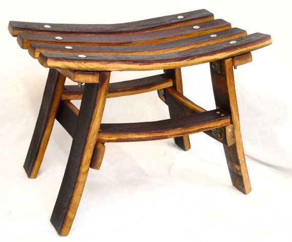 a wooden stool with metal studs on the top and bottom, against a white background