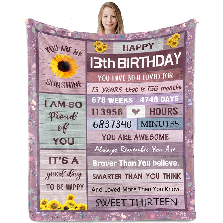 a woman holding up a birthday blanket with sunflowers and words on the front