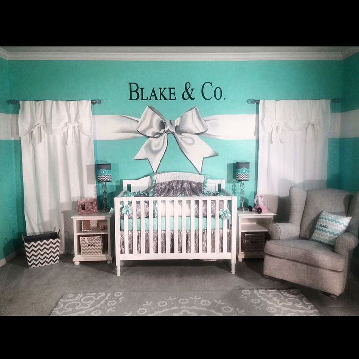 a baby's room decorated in teal and white with a bow on the wall