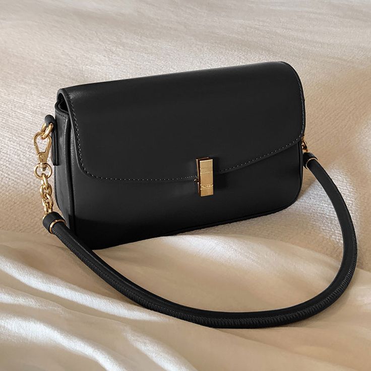 A shoulder bag with a square body and a flap that can hold a smartphone and a small wallet. The golden clasp and small design give it an elegant and stylish impression. It is also possible to remove the shoulder strap. 
 
 
 Color 
 
 Dark brown 
 Black 
 
 
 Size 
 
 
 FREE size 
 
 Height: 14cm 
 Width: 22cm 
 Depth: 6.5cm 
 
 
 
 
 
 Material 
 
 Leather Gold Crossbody Flap Bag With Phone Pocket, Gold Crossbody Flap Bag For Mobile Phone, Trendy Rectangular Flap Bag, Square Baguette Bag With Mobile Phone Holder For Office, Chic Black Flap Bag With Rectangular Case, Square Flap Bag With Hasp Closure For Daily Use, Elegant Everyday Baguette Bag For Mobile Phone, Gold Rectangular Flap Bag For Travel, Chic Gold Baguette Bag With Detachable Strap