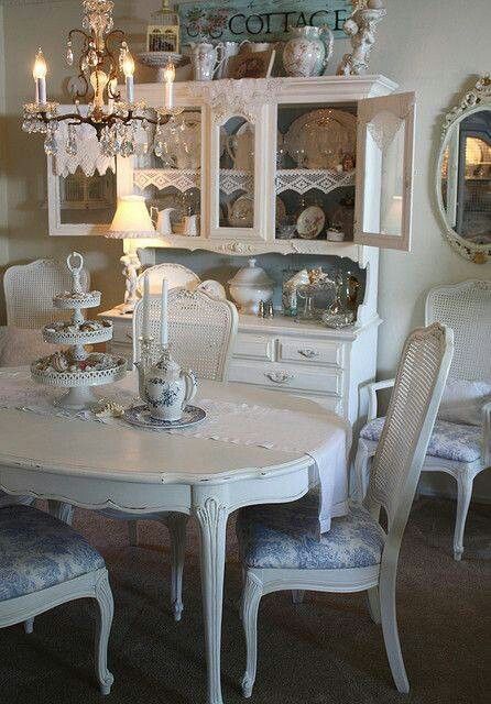 a white dining room table with chairs and china cabinet in the corner, surrounded by other furniture