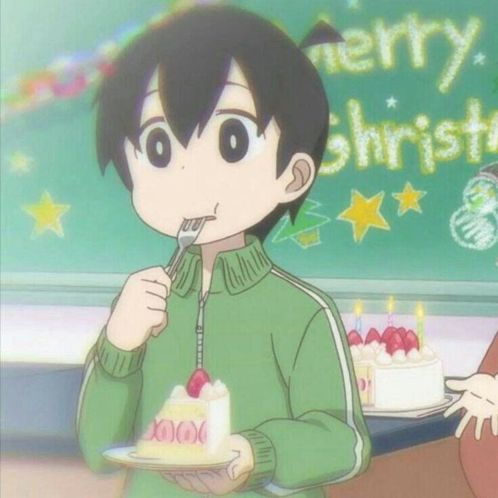 a person holding a plate with a cake on it in front of a sign that says merry christmas