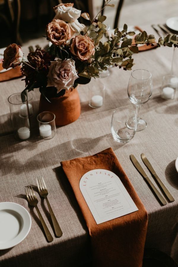 the table is set with silverware and flowers