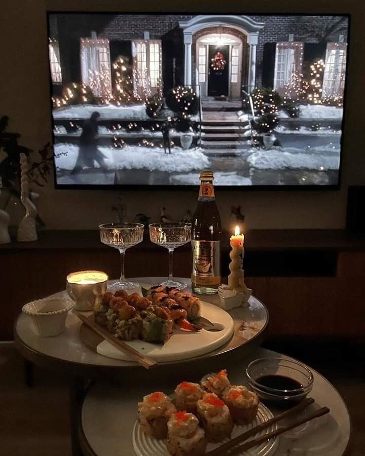 two trays with food and drinks on them in front of a flat screen tv