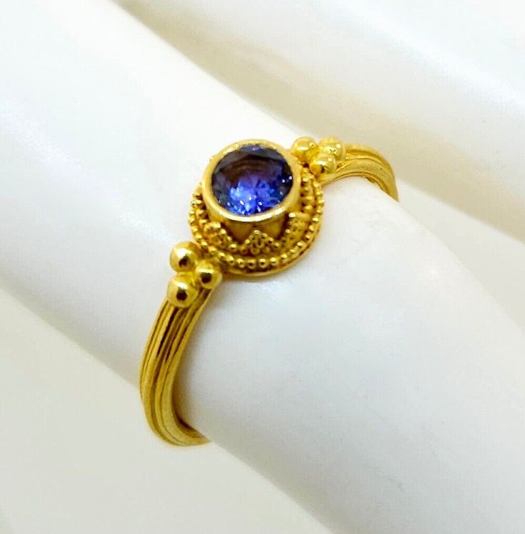 Thank you for viewing this beautiful Kabana 22k yellow gold tanzanite ring.  The ring contains one round bezel set tanzanite measuring approximately 4.5 mm.  The ring weights 3.3 grams.  The ring size is 6.75.   The ring comes with an attractive gift box.   As with all of our items this ring is carefully inspected to insure quality control and authenticity.  We have a multigenerational business presence in the New York Diamond District for 50 years.  I strive to make the jewelry buying experienc Future Jewelry, Tanzanite Ring, Ring Pictures, The Ring, Buying Jewelry, Quality Control, Bezel Setting, 50 Years, Jewelry Watches