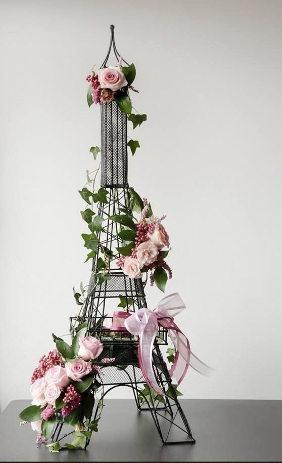 the eiffel tower is decorated with flowers and greenery for an elegant touch