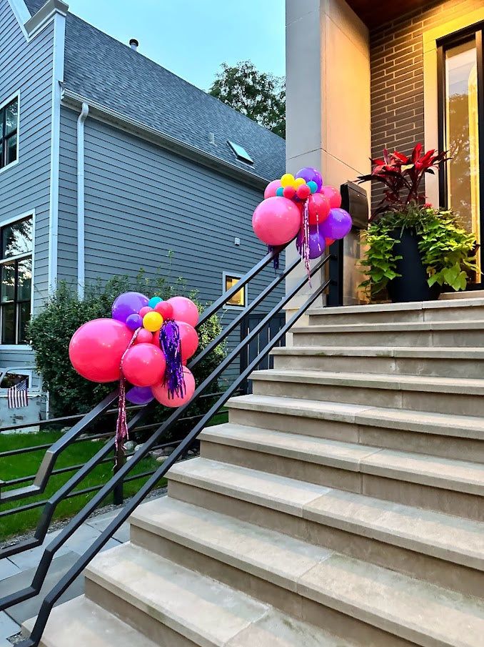 balloons and streamers are tied to the handrails on the stairs outside an apartment building