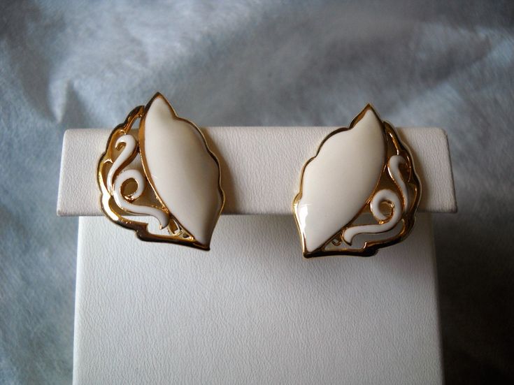 Floral design for this pair of vintage french earrings leaf shape with a white enamel part and a more baroque part crafted in gold and the same tone enamel . These earrings were made in Paris and purchased in the late 70s from ETS. G. Wunsch, who manufactured the ORENA brand with the high quality shown in the photos. The base material is brass and the finishings are 14kt gold and hand painted enamel. This company closed in Dec. 1985 and the ORENA brand vanished from the market. Measurements: wei French Earrings, Leaf Shapes, White Enamel, 14kt Gold, Vintage French, French Vintage, Made In France, Clip On Earrings, Floral Design