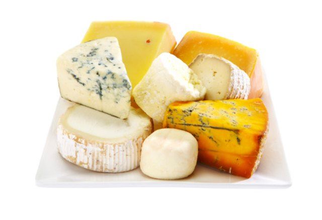 several different types of cheese on a white plate