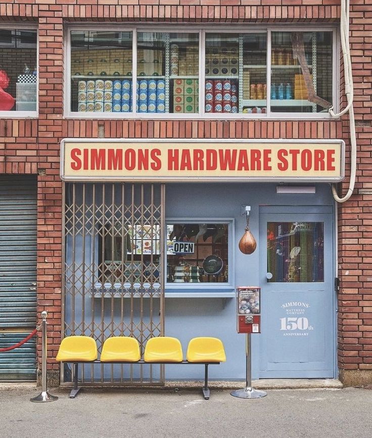 a store front with yellow chairs outside and a red fire hydrant next to it