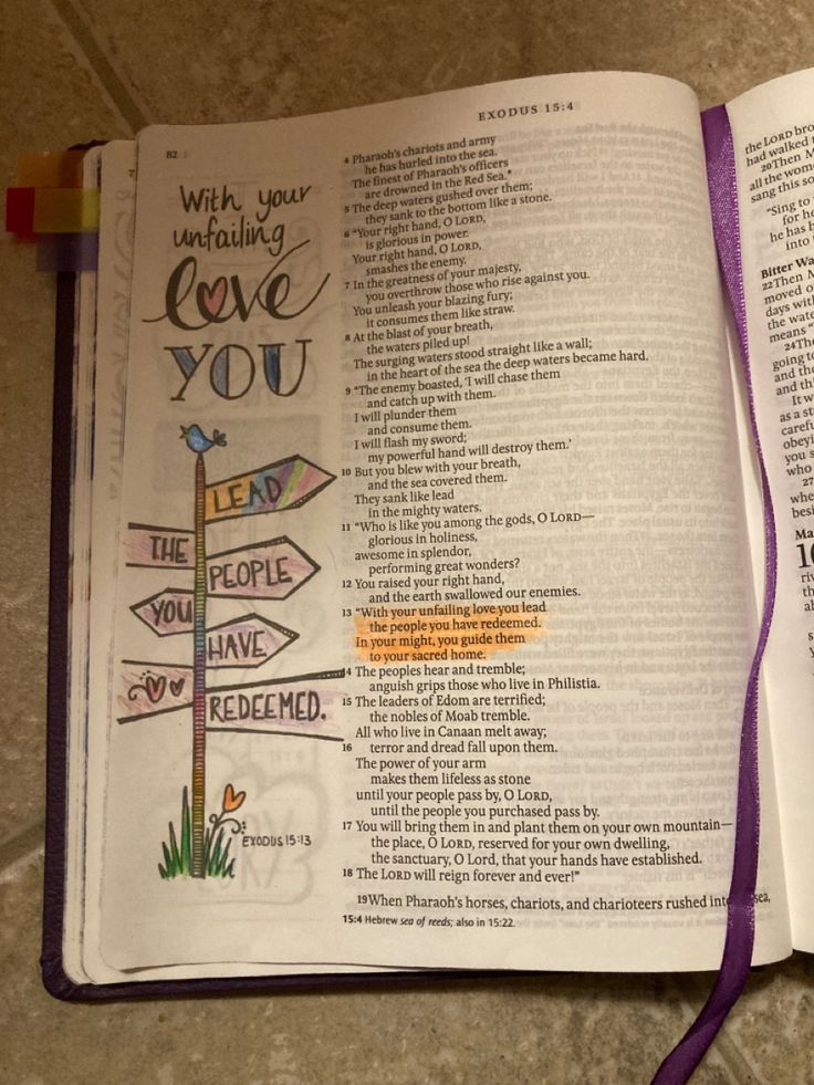 an open bible with the words love you written on it and a purple ribbon attached to one of the pages