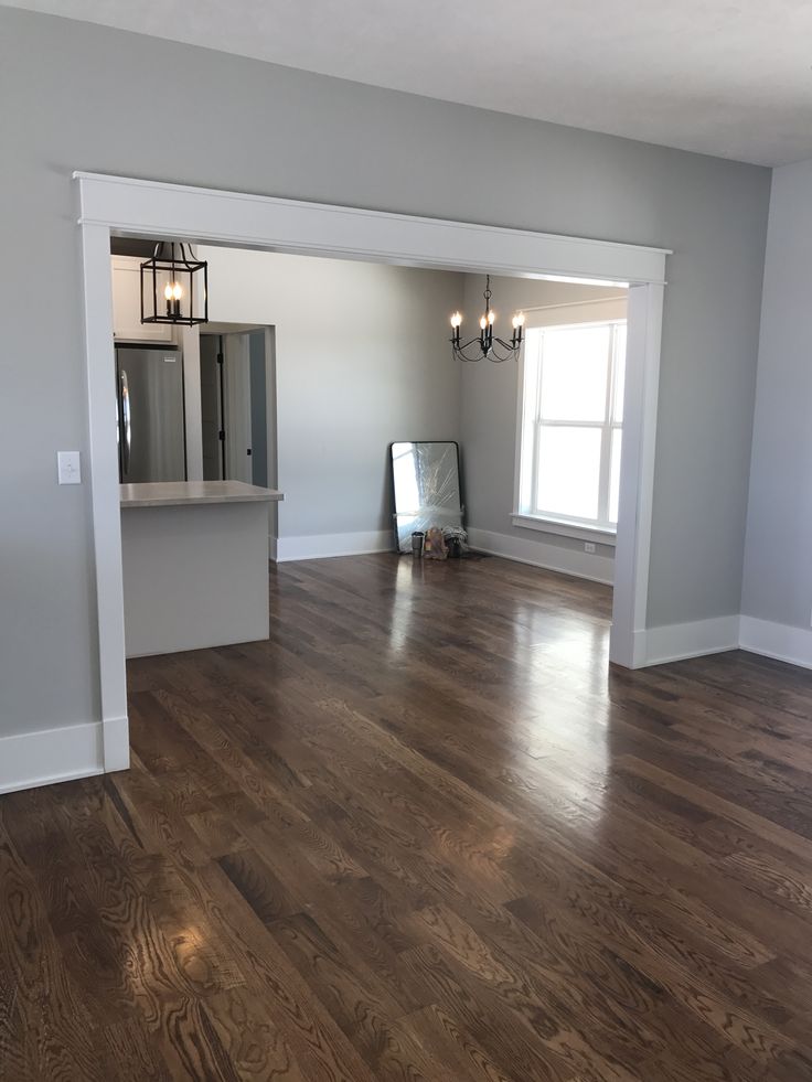 an empty living room with hard wood flooring and white trim on the walls is shown