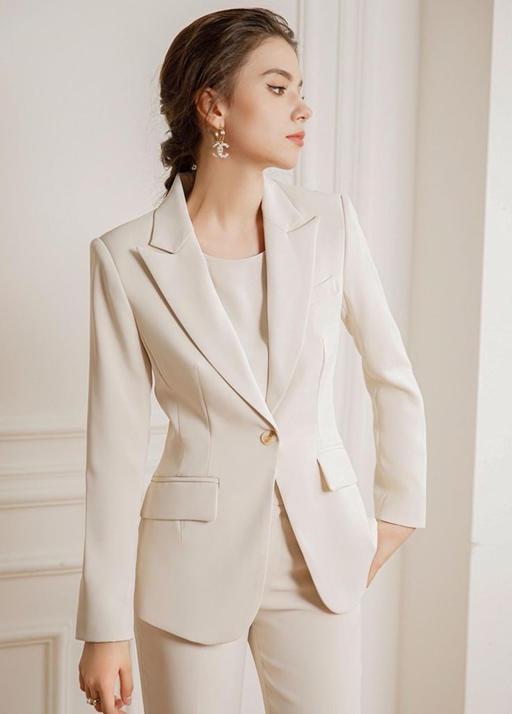 Experience luxury and sophistication in our Three Pcs Beige Pantsuit Set, featuring a beautiful silk blouse and pants made of the finest quality silk. Elevate your wardrobe with this exclusive set, perfect for any occasion. Three Pcs Beige Pantsuit Set Description: Peak lapels; front button blazer V-neck, Long sleeves; button cuffs. Structured shoulders. Chest welt pockets. Hip flap pockets Polyester 100% Silk blouse Wide leg loose fit pants Imported Brand - Aision Model Number - 22CPB82 Washing Cream Women Suits, Beige Suits Women, Outfit Jas, Beige Pantsuit, Pantsuits For Women Business, Tailored Blazer Women, Cotton Tops Designs, Blouse And Pants, Blazer Suit Women