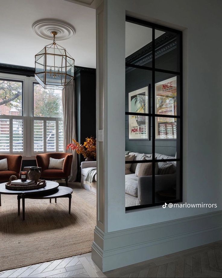 a living room filled with furniture and large windows