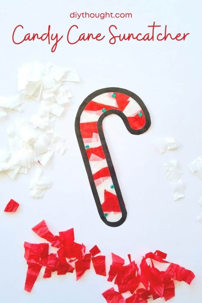 a candy cane suncather made out of tissue paper on top of shredded red and white paper