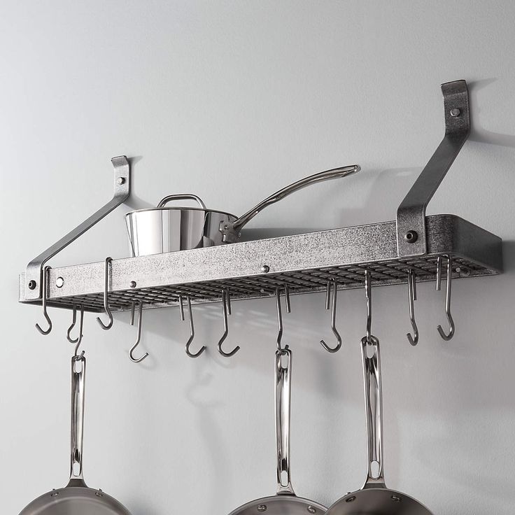 pots and pans hanging from hooks on a wall