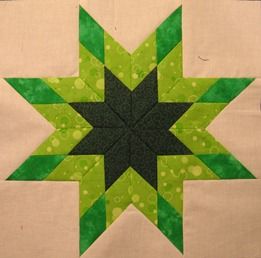 a green and black star quilted onto a piece of cloth