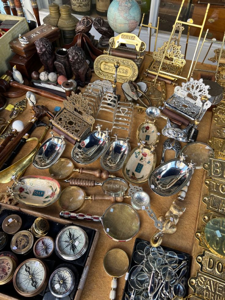 there are many different types of clocks on the table and in front of them is an antique clock