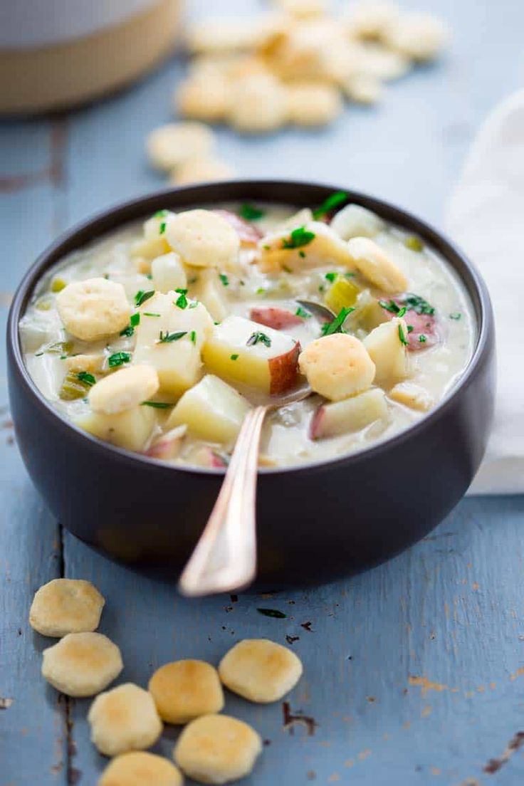 a black bowl filled with potato soup on top of a blue table