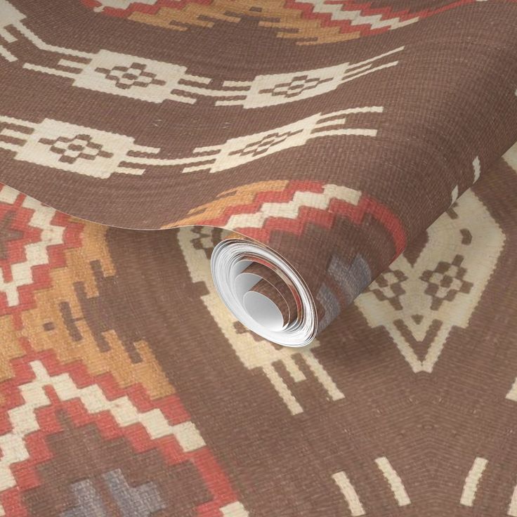 a brown and white area rug with an intricate design on the bottom, along with a roll of tape