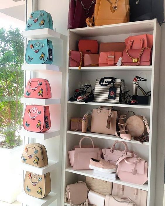 many purses and handbags are displayed on shelves