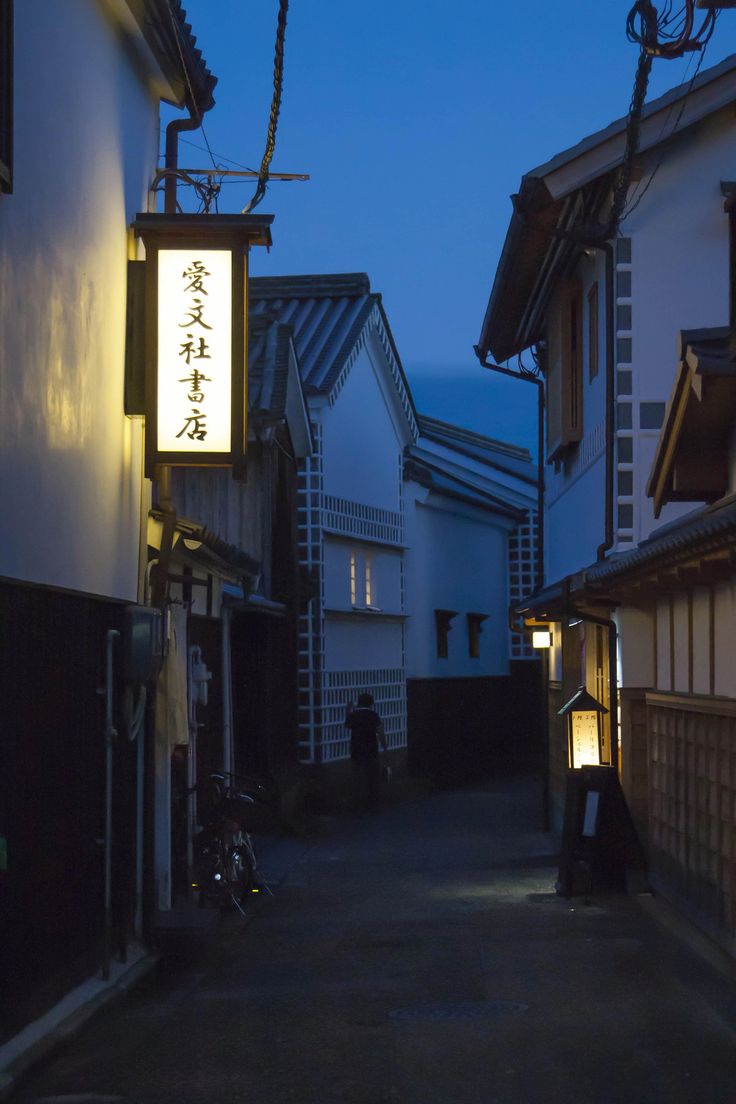 an alley way with buildings and lights at night