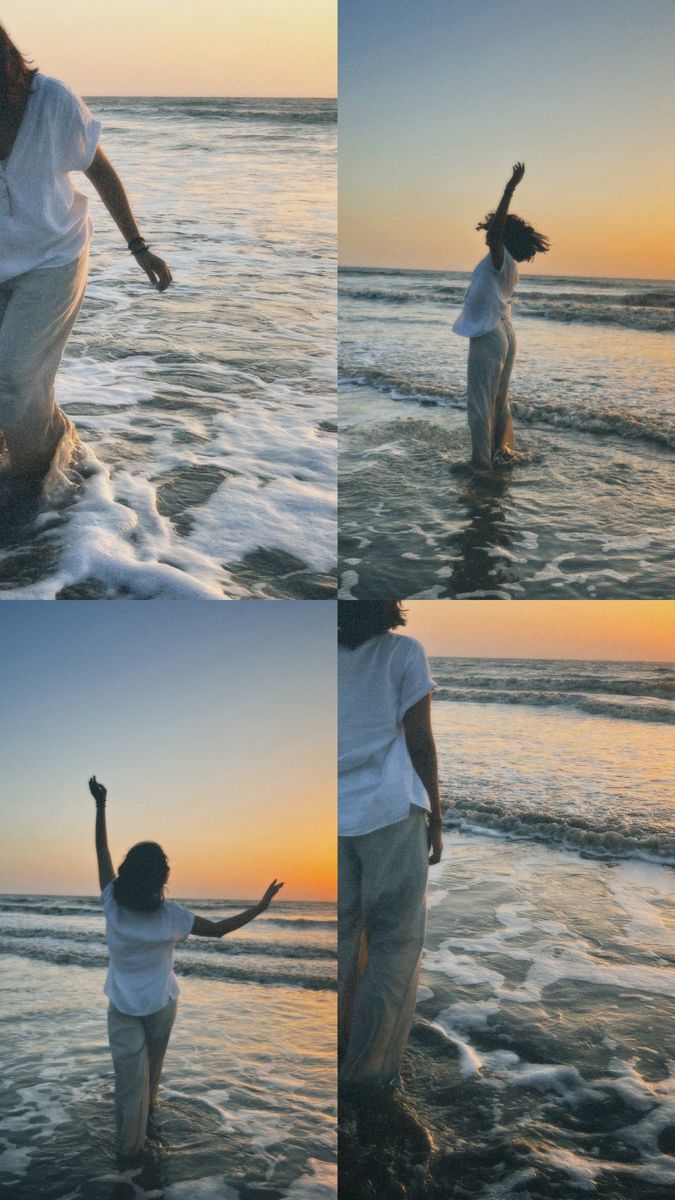 a woman standing on top of a sandy beach next to the ocean holding her arms in the air