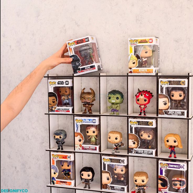 someone is holding up some funky pop vinyls on a shelf with other figurines