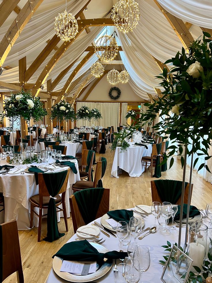 tall flower centre pieces with lots of geenery and forest green napkins Forest Green Wedding Reception Decor, Forest Green Table Setting Wedding, Dark Green Wedding Reception Tables, Woodsy Indoor Wedding, Dark Green Aesthetic Wedding, Forest Green Table Setting, Forest Green Wedding Centerpieces, Forest Green And Grey Wedding, Midnight Blue And Forest Green Wedding