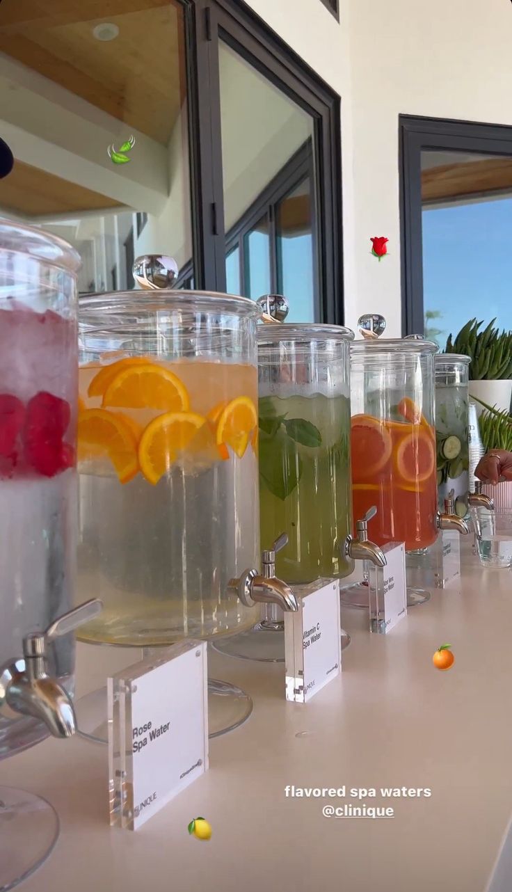 there are many different types of drinks on the counter top, including lemons and water