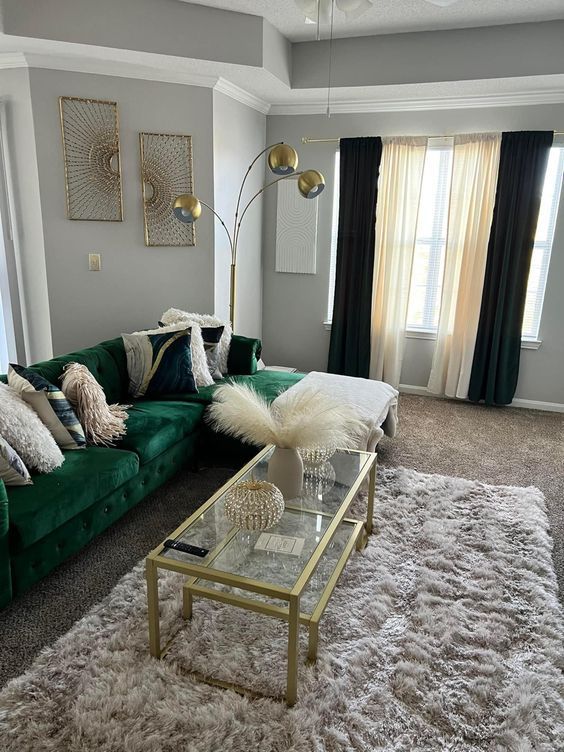 a living room filled with green couches and pillows on top of a shaggy rug