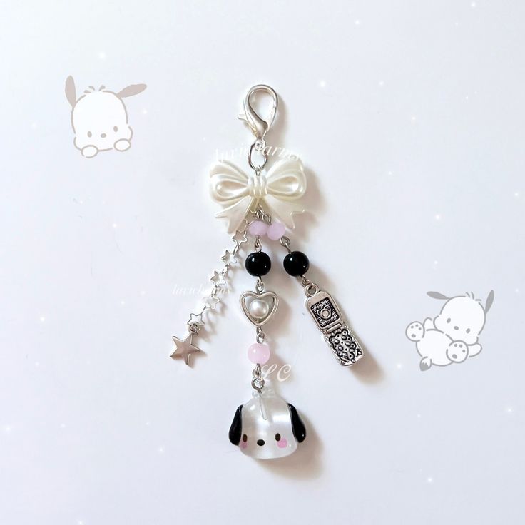 a keychain with charms attached to it on a white surface next to other items