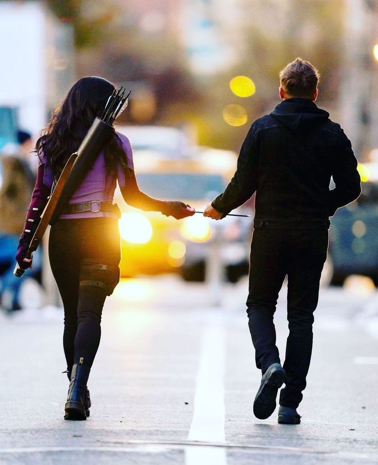 two people walking down the street holding hands