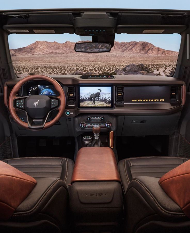 the interior of a truck with brown leather seats and dashboard, including an entertainment system