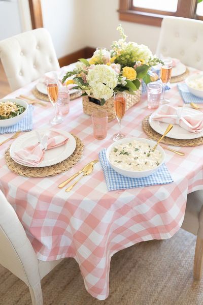 a table set with plates, glasses and flowers