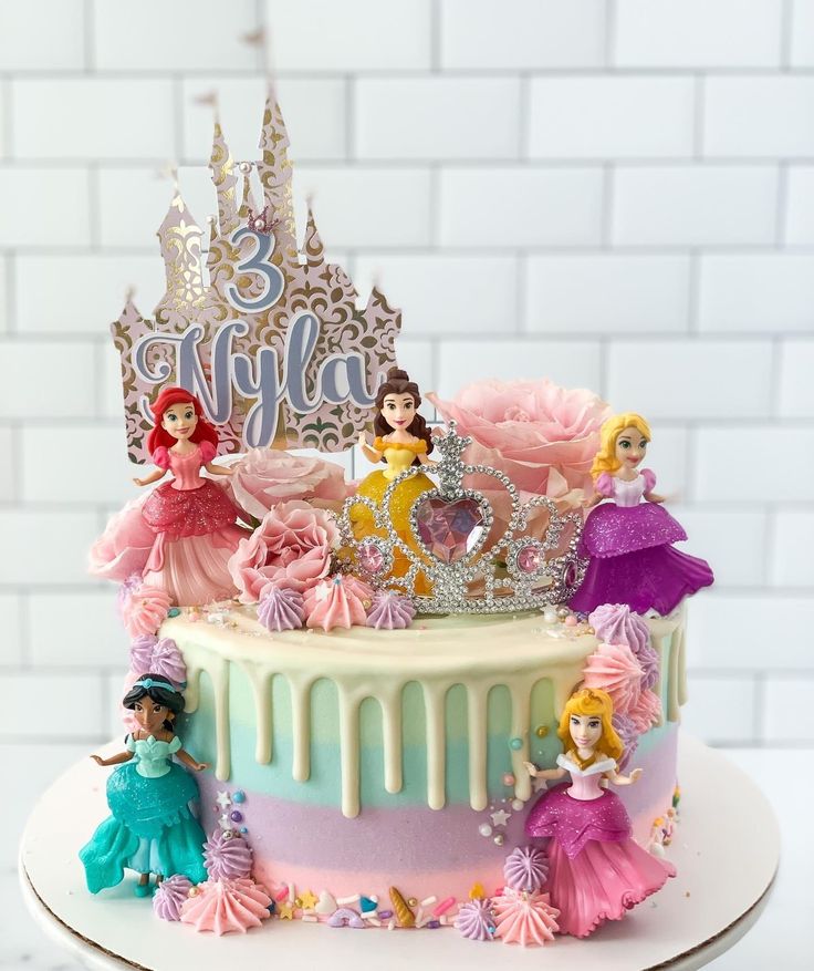 a birthday cake with princess figures on it