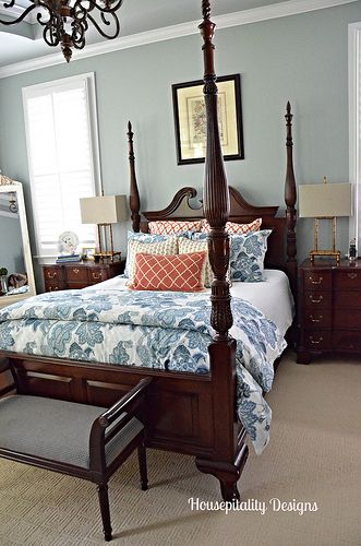 a bedroom with a four post bed and blue walls