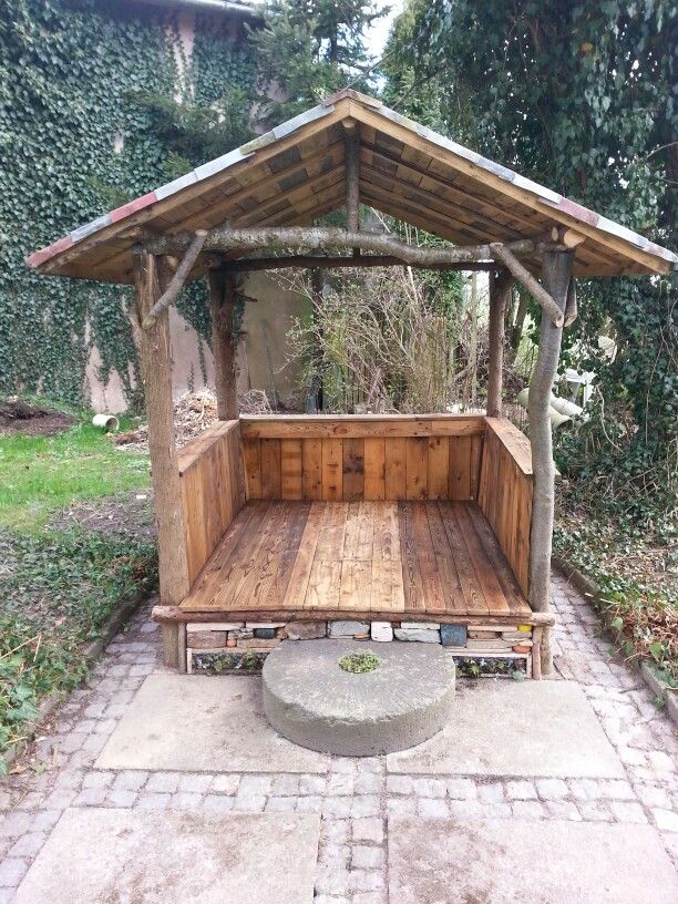 a wooden gazebo sitting in the middle of a yard next to a brick walkway