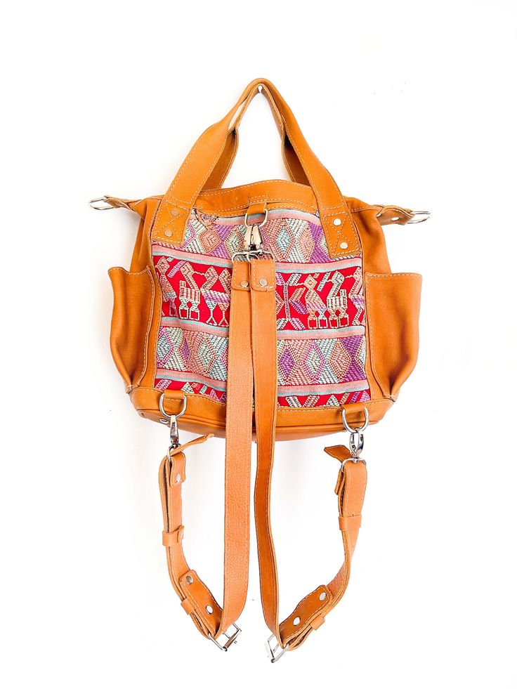 Convertible full grain leather bag with removable straps to wear in three different ways. Includes leather cross body strap and a pair of backpack straps. This mini backpack is made using a traditional huipil from the village of Chichicastenango, Quiché. - 100% foot loomed cotton lining - Artisan made woven huipil- One interior zipper pocket, zipper closure- Hand sanitizer included as in picture- Inside Pockets- Two exterior open pockets - Full camel grain leather - Zipper closure * This bag is Travel Shoulder Bag With Adjustable Strap In Camel, Bohemian Everyday Bag With Strap, Bohemian Crossbody Bag With Strap, Leather Satchel Backpack With Handles, Travel Shoulder Bag With Handles In Camel, Camel Shoulder Bag With Handles For Travel, Bohemian Shoulder Bag With Detachable Strap For Travel, Everyday Bohemian Bag With Strap, Bohemian Crossbody Bag