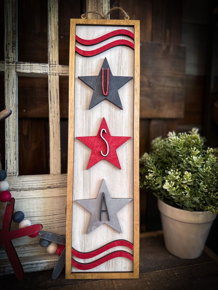 a wooden sign with three stars hanging from it's sides and the letter u on top