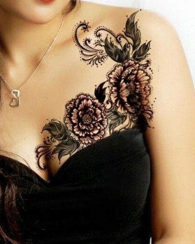 a woman with tattoos on her chest and shoulder