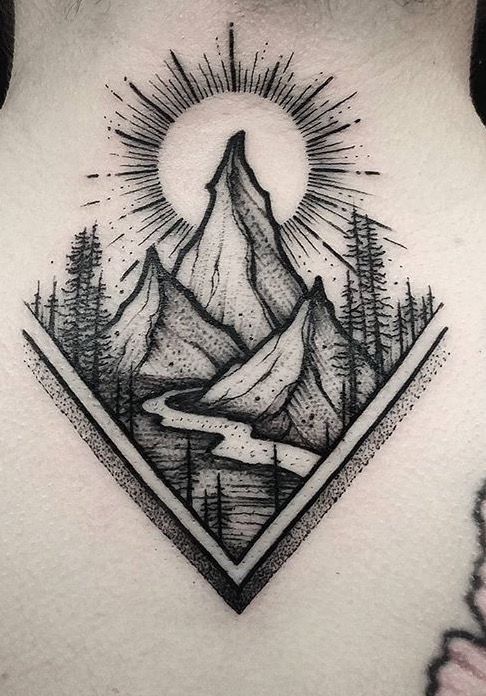 the back of a woman's neck with mountains and trees on it