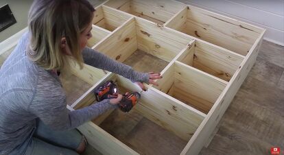 a woman is working on some wooden drawers